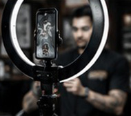 Creator filming barber content with a ring light